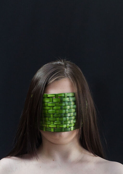 Portrait einer jungen Frau mit grüner Maske aus Pflanzenfasern, Portrait ohne Gesicht, CloseUp