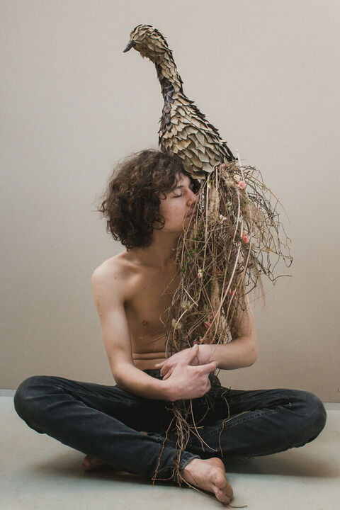 Portraitaufnahme, Junger Mann mit floralem Kunstwerk auf der Schulter, Vogel, Portrait