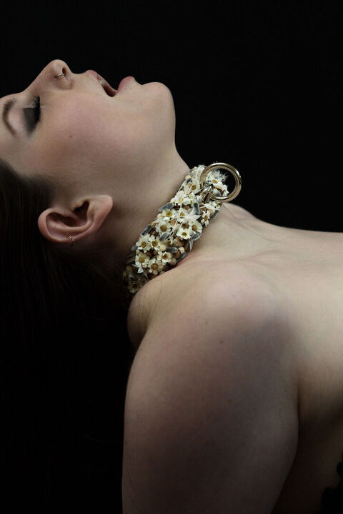 Laszives Portrait einer jungen Frau mit floralem Halsband mit Öse