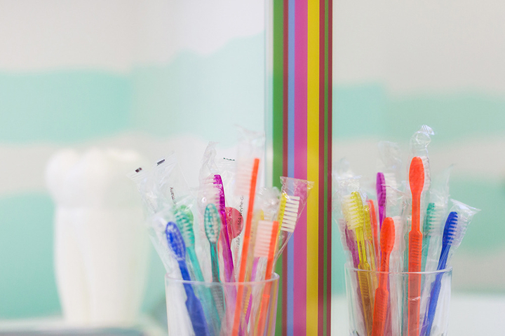 Bunte Zahnbürsten im Becher beim Kinderzahnarzt